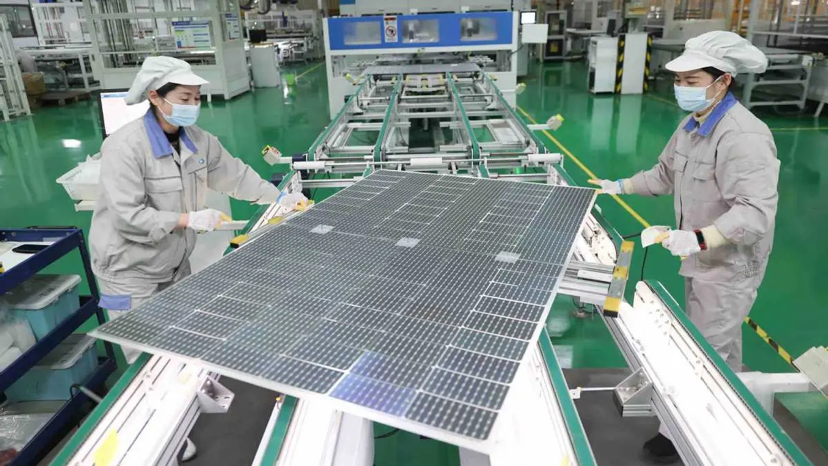 Longi lider chińskiej branży fotowoltaicznej Logo firmy Longi Green Energy z halą pełną gotowych modułów solarnych