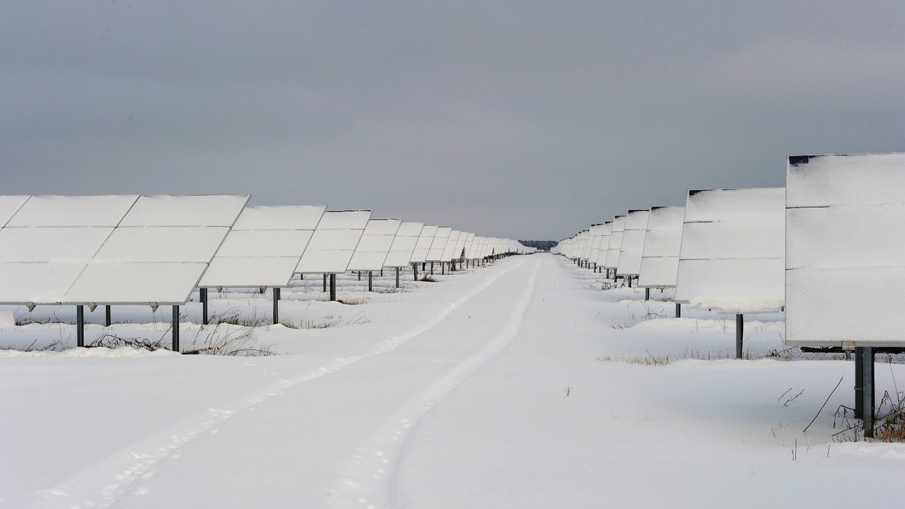 Wpływ śniegu na wydajność paneli solarnych Czyste panele fotowoltaiczne obok tych zasypanych grubą warstwą świeżego śniegu