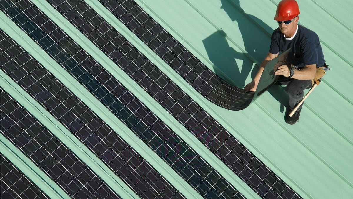 cienka elastyczna mata solarna rozłożona na trawie obok zwiniętej rolki
