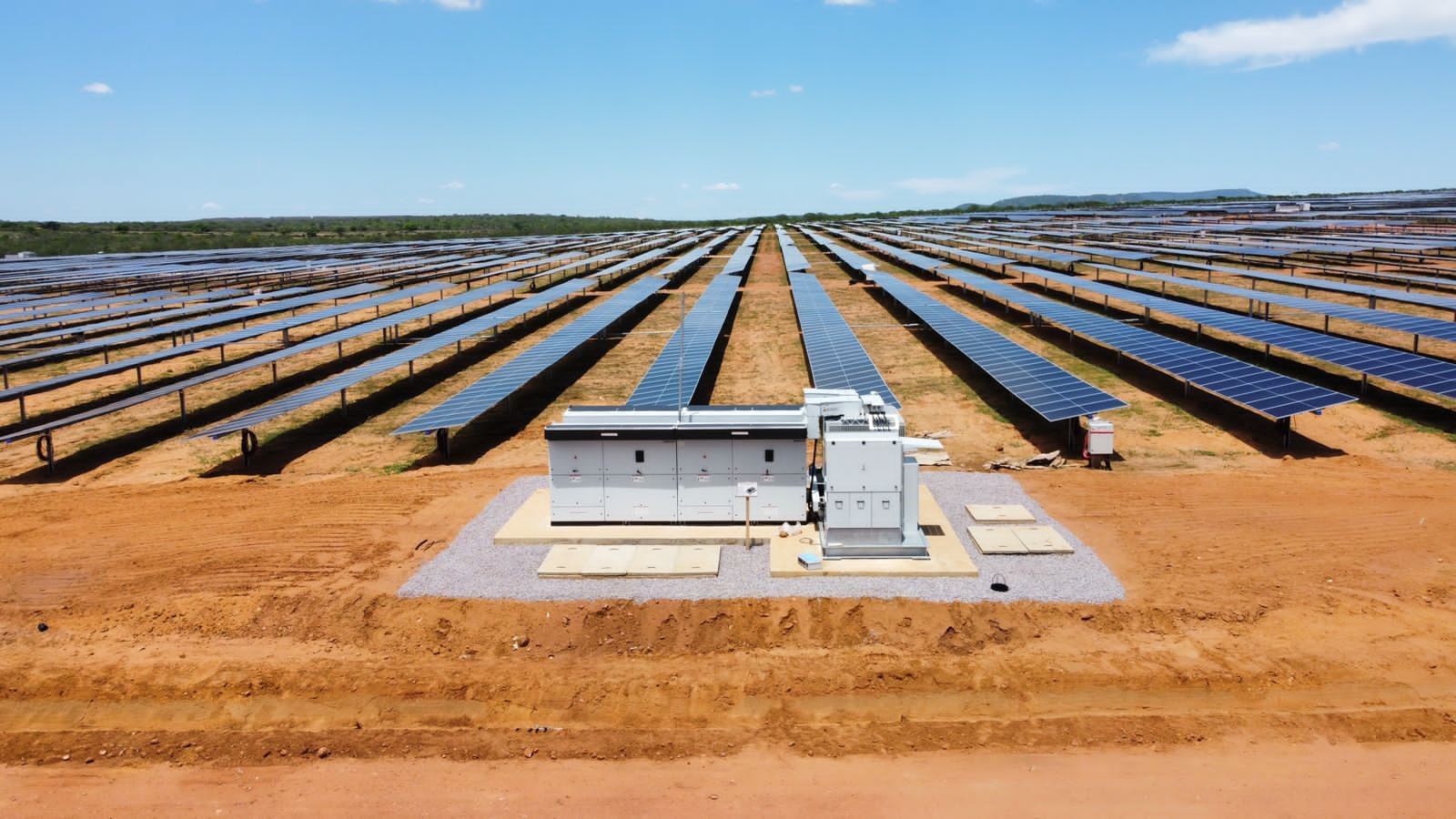 Bliski widok transformatora solarnego Duży metalowy transformator z radiatorami i przewodami na betonowej platformie